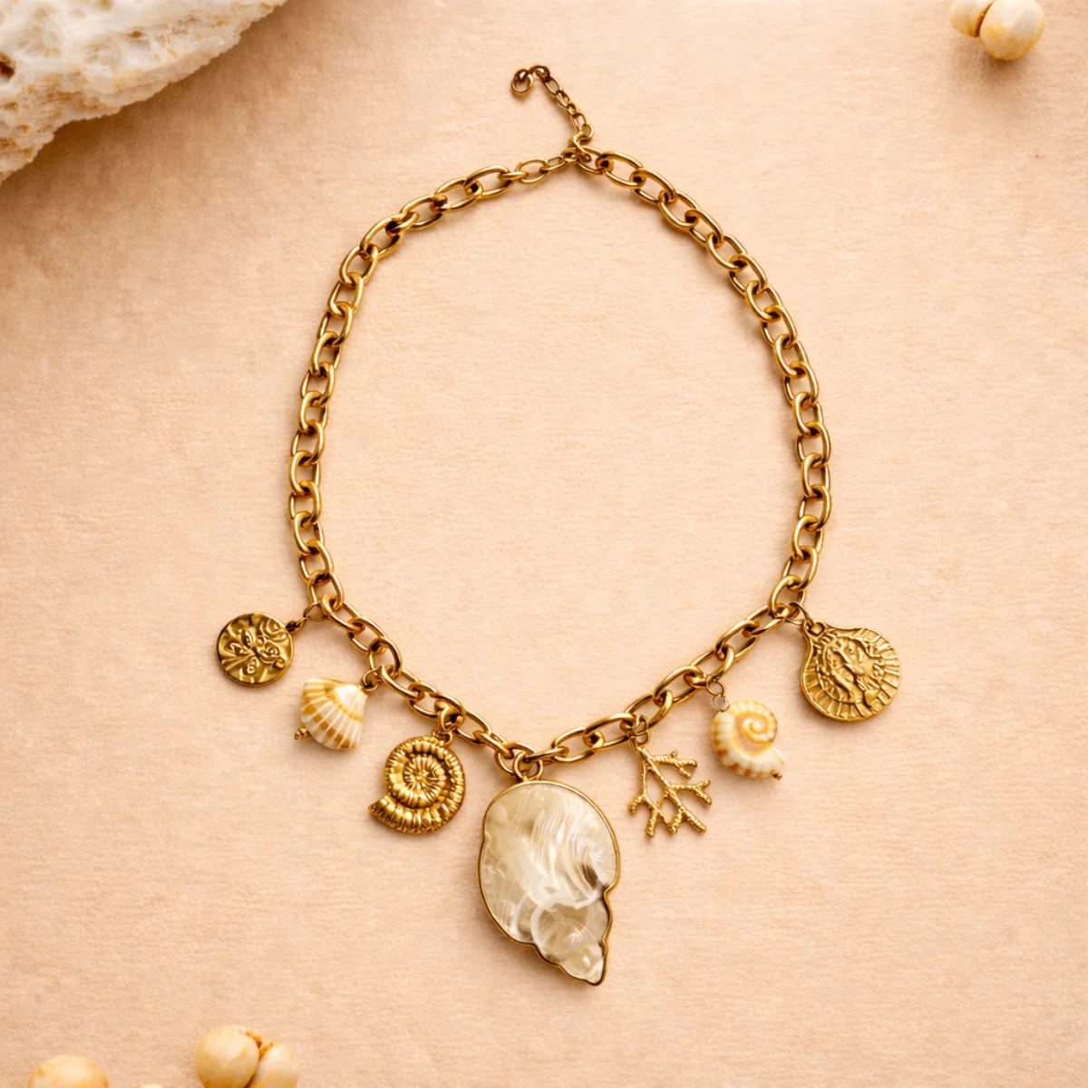 Collier Nerea doré avec charms marins sur fond sable